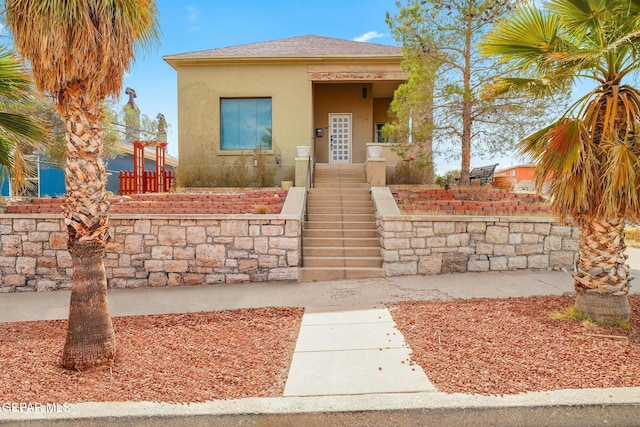 view of front of home with roof with shingles and stucco siding