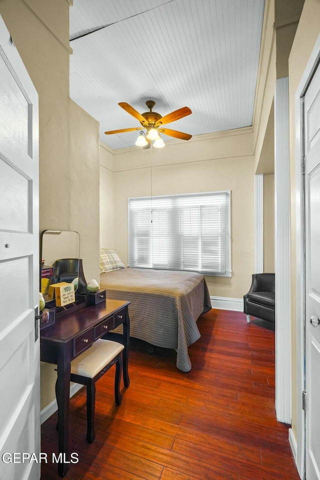 bedroom with a ceiling fan, wood-type flooring, crown molding, and baseboards