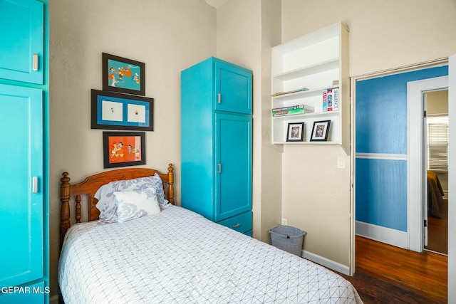 bedroom with dark wood-style floors and baseboards