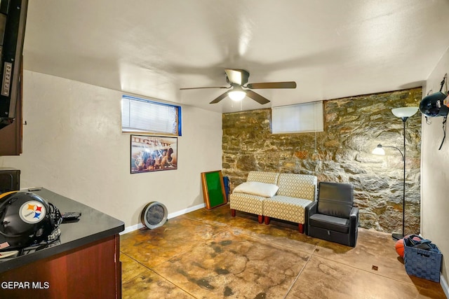 interior space with a ceiling fan and baseboards