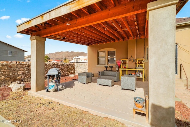 view of patio / terrace featuring a mountain view, a grill, and fence