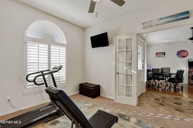 exercise room featuring baseboards, a ceiling fan, and french doors