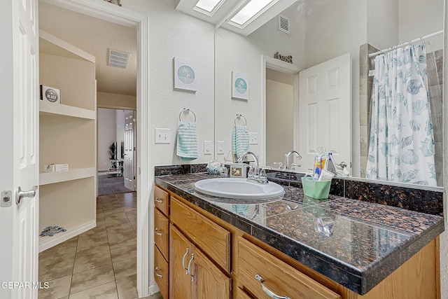 bathroom featuring a skylight, tile patterned flooring, visible vents, and vanity