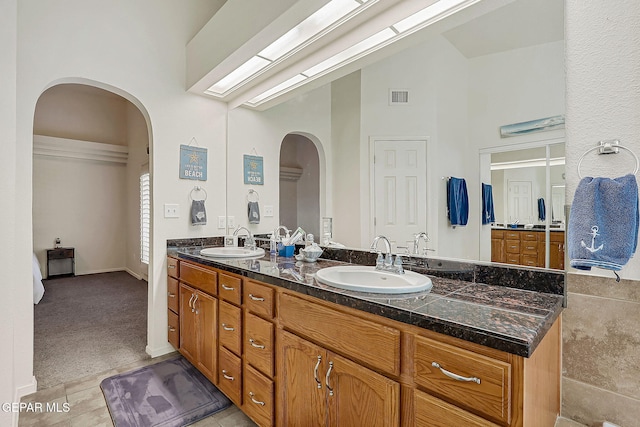 full bath featuring tile patterned flooring, visible vents, a sink, and double vanity