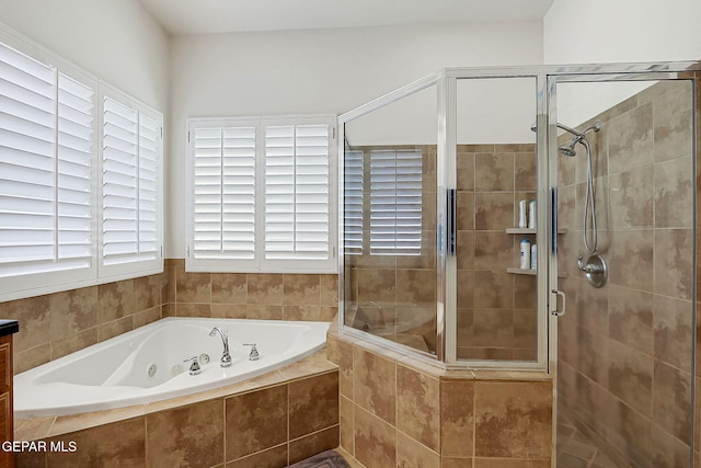 bathroom featuring a shower stall and a tub with jets