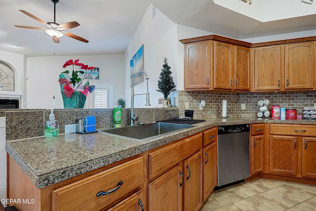 kitchen with dishwasher, a peninsula, backsplash, and brown cabinets