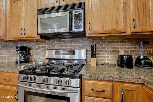 kitchen with tile countertops, tasteful backsplash, stainless steel range with gas stovetop, and brown cabinets