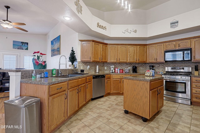 kitchen featuring decorative backsplash, a peninsula, stainless steel appliances, a sink, and light tile patterned flooring