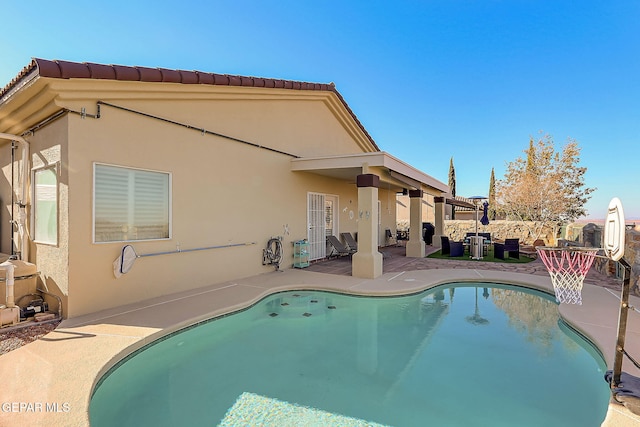 outdoor pool with a patio and fence