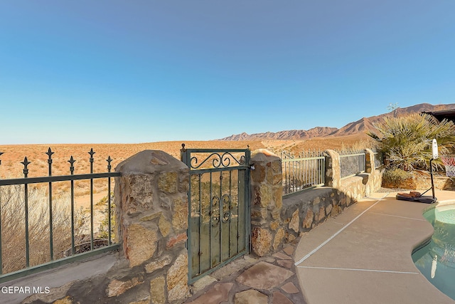 view of gate featuring fence and a mountain view