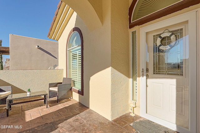 doorway to property featuring stucco siding