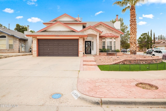 traditional-style home featuring brick siding, an attached garage, concrete driveway, and fence