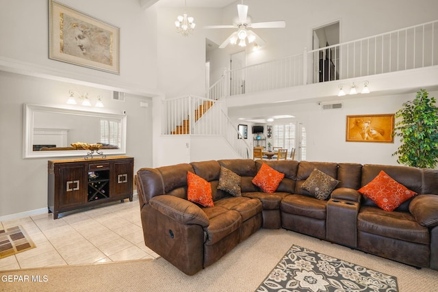 living room featuring light tile patterned floors, visible vents, arched walkways, and stairs