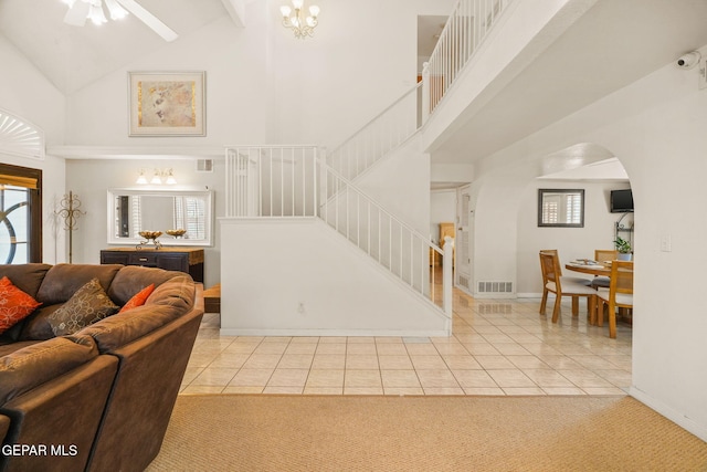 interior space featuring arched walkways, stairway, visible vents, and a towering ceiling