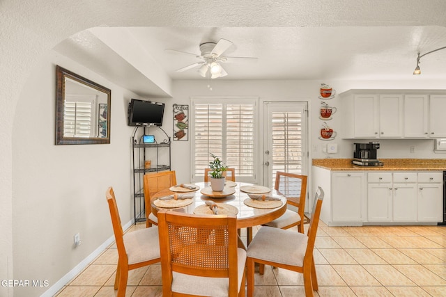 dining room featuring light tile patterned floors, baseboards, ceiling fan, track lighting, and a textured ceiling