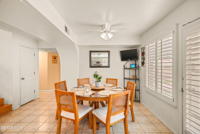 dining area featuring plenty of natural light, arched walkways, visible vents, and light tile patterned floors