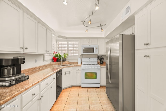 kitchen featuring white appliances, visible vents, light tile patterned flooring, a sink, and white cabinets