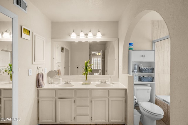 full bathroom featuring a sink, visible vents, toilet, and double vanity