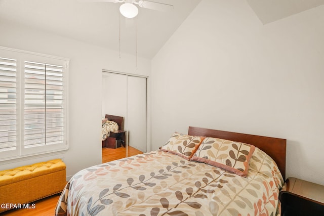 bedroom featuring a ceiling fan, lofted ceiling, wood finished floors, and a closet