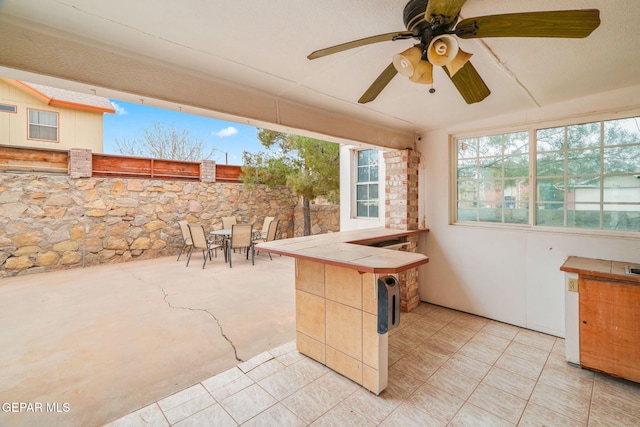 view of patio with outdoor dining space, a ceiling fan, and fence