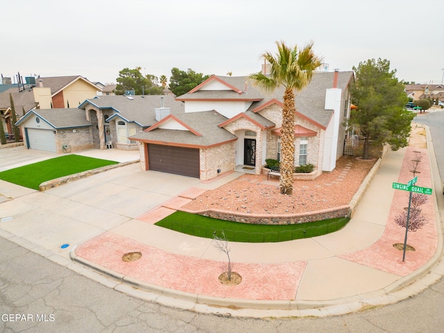 traditional home with a garage, concrete driveway, and a shingled roof