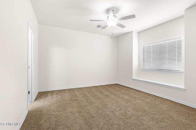 carpeted empty room featuring visible vents, ceiling fan, and baseboards