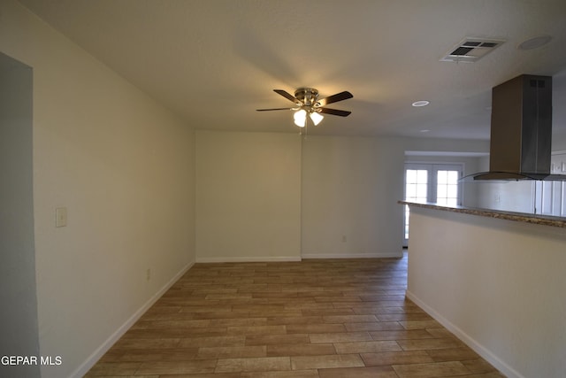 spare room with visible vents, light wood-style flooring, and baseboards