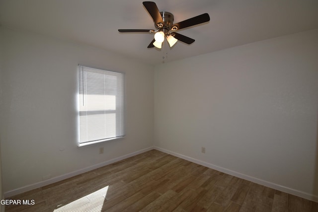 unfurnished room featuring wood finished floors, a ceiling fan, and baseboards