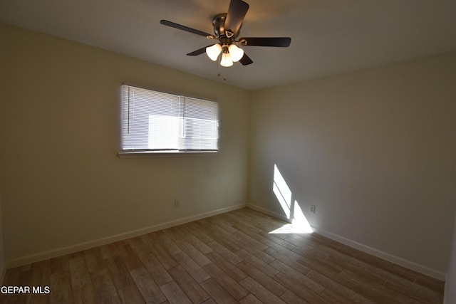 spare room with a ceiling fan, baseboards, and wood finished floors