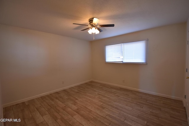 spare room with ceiling fan, baseboards, and wood finished floors