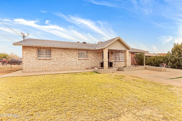 ranch-style house featuring a front yard, brick siding, a patio, and fence