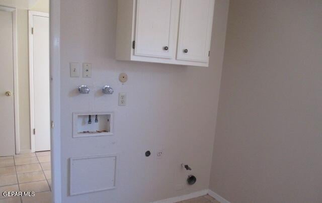 washroom featuring light tile patterned floors, cabinet space, hookup for a gas dryer, hookup for a washing machine, and hookup for an electric dryer