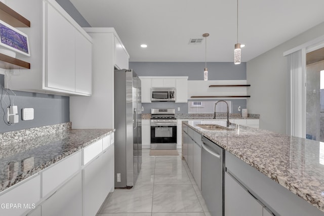 kitchen with decorative light fixtures, open shelves, appliances with stainless steel finishes, white cabinets, and a sink