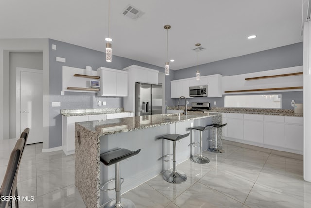 kitchen with open shelves, stainless steel appliances, visible vents, white cabinets, and a sink