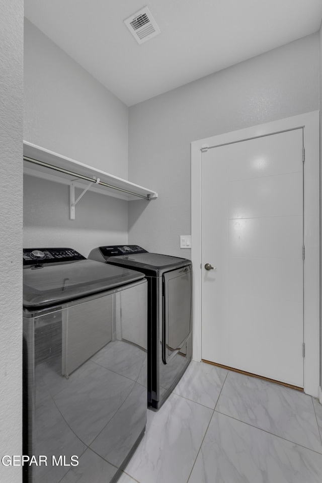 laundry room featuring laundry area, visible vents, washer and clothes dryer, and marble finish floor