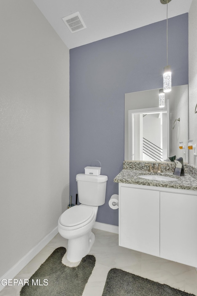 bathroom featuring toilet, baseboards, visible vents, and vanity