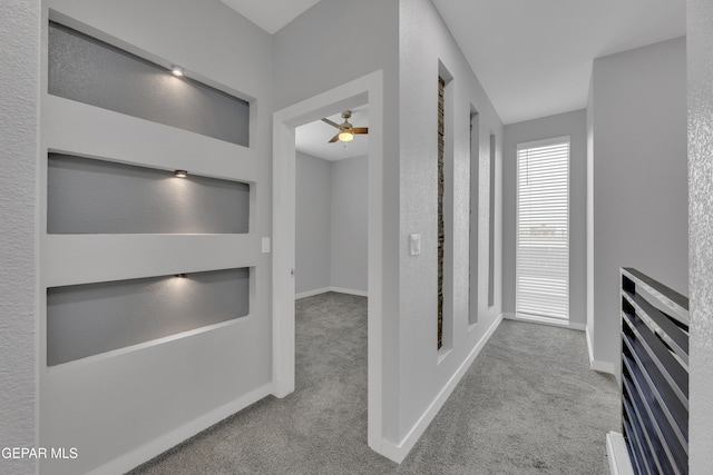 hallway featuring carpet flooring and baseboards