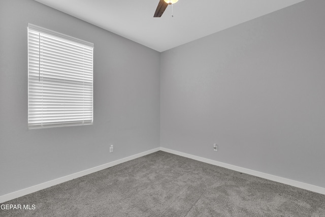 carpeted empty room with a ceiling fan and baseboards