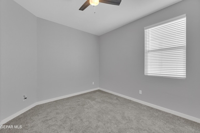 unfurnished room with carpet floors, baseboards, and a ceiling fan