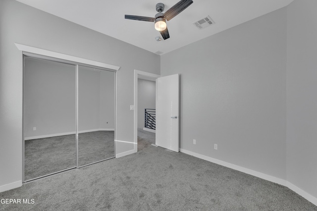 unfurnished bedroom featuring carpet floors, baseboards, visible vents, and a closet