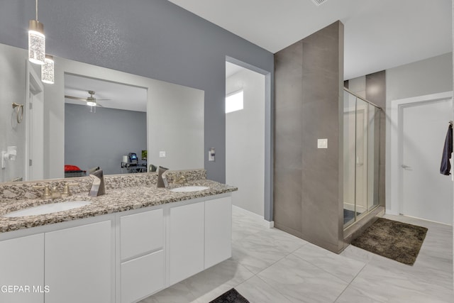 bathroom with double vanity, marble finish floor, a shower stall, and a sink