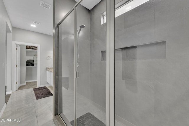 full bath featuring a shower stall, a spacious closet, and visible vents