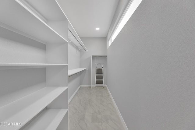 spacious closet with marble finish floor