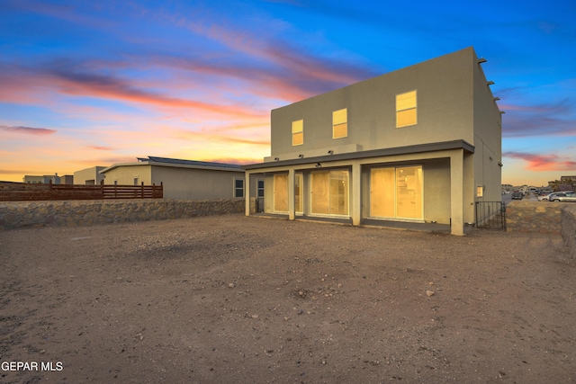 rear view of property with fence and stucco siding