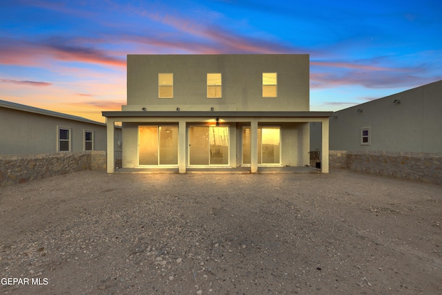 back of property with a patio and stucco siding