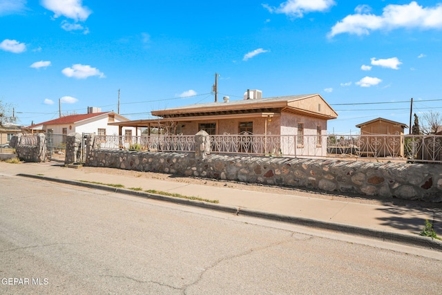 view of front of home with a fenced front yard and stucco siding