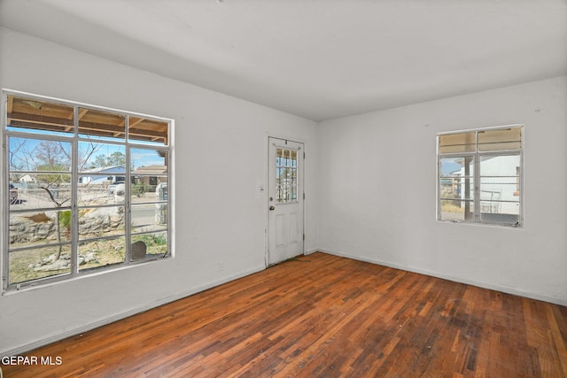 spare room with hardwood / wood-style floors and baseboards