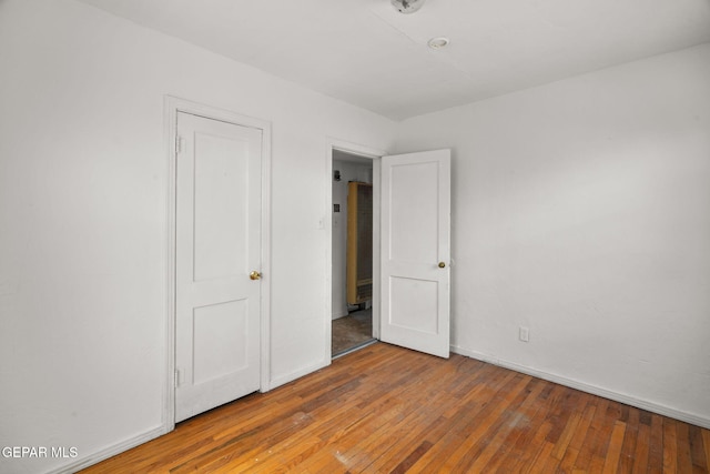 unfurnished bedroom featuring baseboards and wood-type flooring