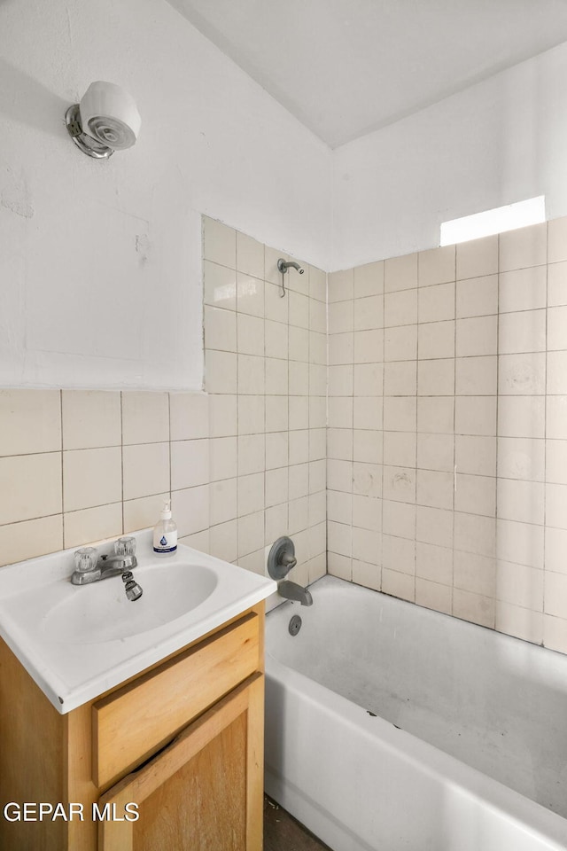 bathroom featuring vanity, tile walls, tasteful backsplash, and shower / bathtub combination