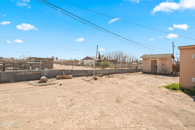 view of yard with an outdoor structure, a storage unit, and fence